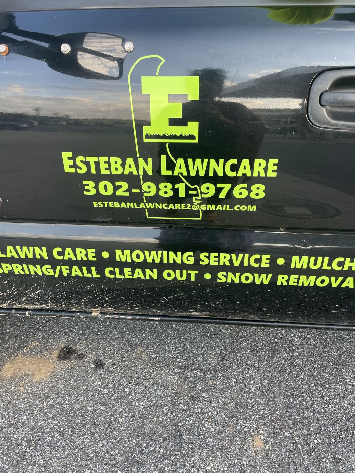 Esteban Lawncare logo and phone number on the truck door