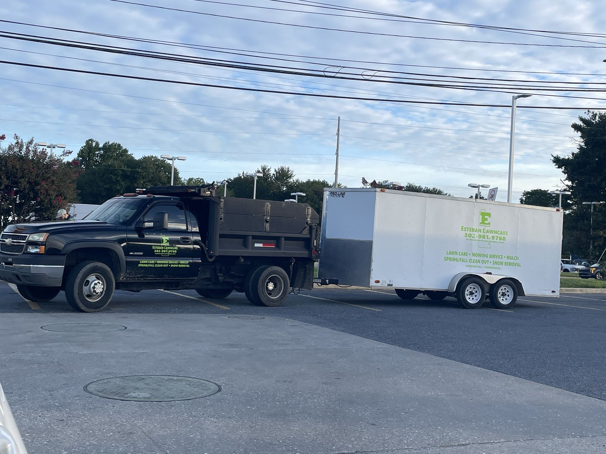 Esteban Lawncare dump truck towing the branded equipment trailer